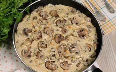 Fried mushrooms in a creamy sauce cooked in a frying pan